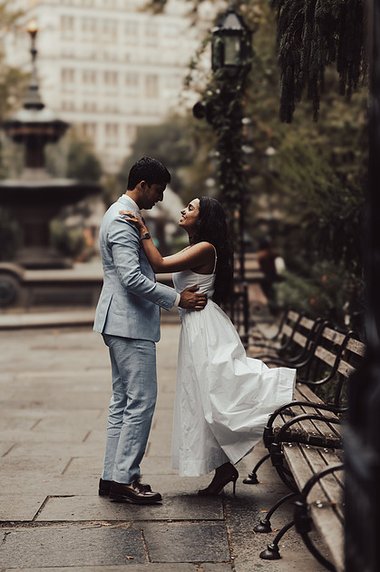 Couple walking through City Hall Park during wedding portraits.