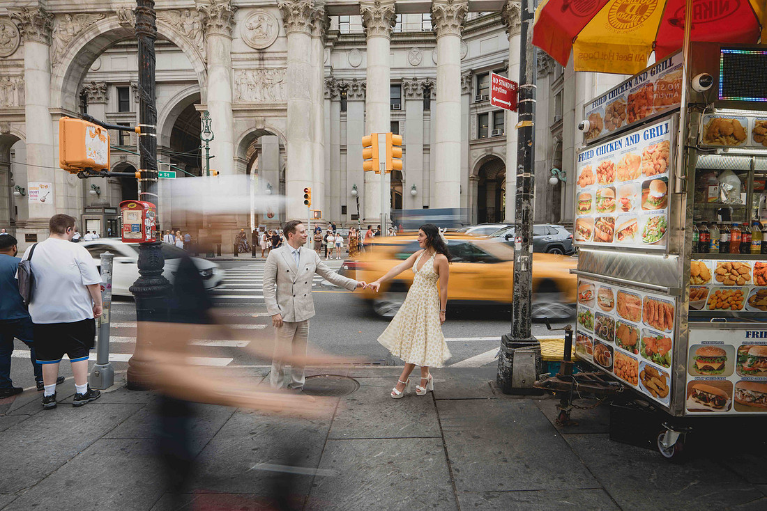 Couple walking through a busy New York City street after their City Hall wedding.