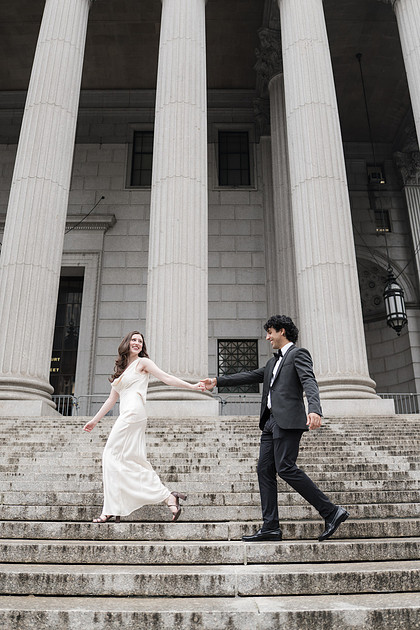 Wedding couple photographed on grand courthouse steps after a City Hall ceremony.