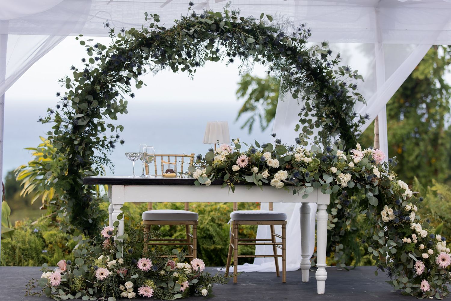 Floral wedding ceremony arch set for an outdoor celebration.